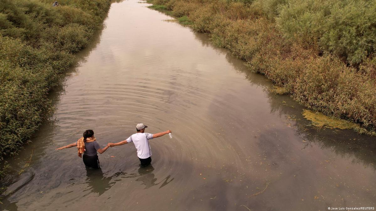 Dos migrantes cruzan las aguas del Río Bravo con la intención de llegar al territorio estadounidense.
